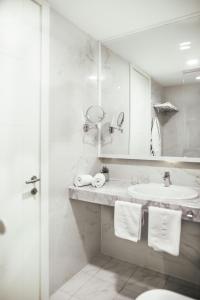 a white bathroom with a sink and a mirror at City Beach Makarska in Makarska