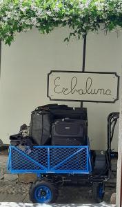 オッジェッビオにあるResidenza Erbalunaの看板の下に座る荷物の荷車