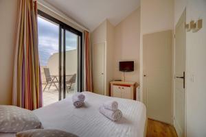 ein Hotelzimmer mit einem Bett mit Handtüchern darauf in der Unterkunft IMMOGROOM - 2BR - sea view - Swimming pool - Terrace - Parking - AC - Wifi in Cannes