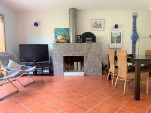 a living room with a fireplace and a table and chairs at Quinta da Boavista in Caminha
