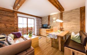 a living room with a couch and a table at Landhaus Pichler in Tannheim