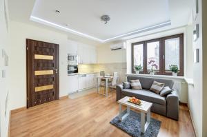 New Apartments Wieniawa في لوبلين: غرفة معيشة مع أريكة وطاولة
