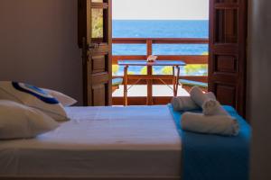 a bedroom with a bed and a view of the ocean at Mistral-Patmos in Patmos
