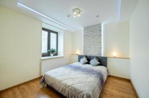 New Apartments Wieniawa في لوبلين: غرفة نوم بسرير وجدار من الطوب
