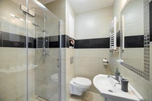 a bathroom with a toilet and a shower and a sink at New Apartments Wieniawa in Lublin