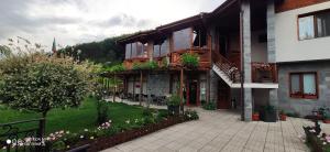 a house with a patio and a yard with flowers at Alpine Garden Hotel (Trayanovi Dvori) in Simitli