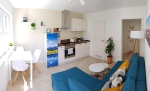 a living room with a blue couch and a kitchen at Apartment Charly - Aktivurlaub im Herzen Bayerns in Wolfersdorf