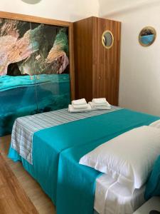 a bedroom with a blue bed with a painting on the wall at Grotta Verde Luxury Suite by CapriRooms in Capri