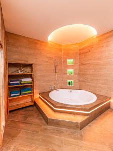 ein großes Bad mit Badewanne in einem Zimmer in der Unterkunft Murtal Suiten in Zeltweg