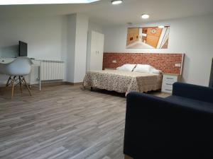 sypialnia z łóżkiem i ścianą z cegły w obiekcie Edificio Valles del Lúpulo (DUPLEX) w mieście Astorga