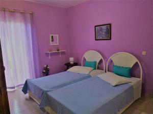 a bedroom with a large bed with purple walls at Violet Bedroom and Apartment in Spata
