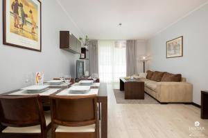 uma sala de estar com uma mesa e um sofá em Jantar Apartamenty - AQUARIUS Apartamenty em Kolobrzeg