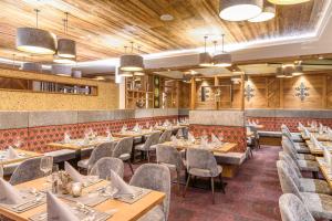 a restaurant with wooden ceilings and tables and chairs at Hotel Wagrainerhof in Wagrain