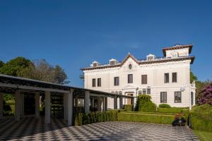 Una gran casa blanca con un patio enfrente. en Hotel Pazo Libunca en Narón