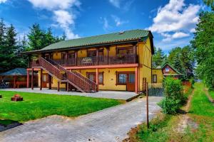 a large yellow house with a balcony at okuninkanoclegi in Okuninka