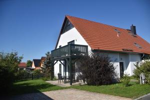 a white house with a red roof and a balcony at Ferienwohnung Am Hegebusch in Altendorf