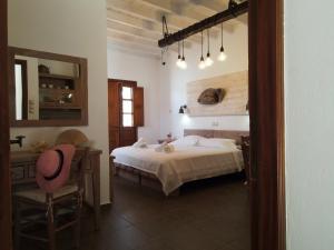 a bedroom with a bed and a table and a chair at Mistral-Patmos in Patmos