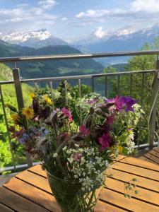 a vase of flowers sitting on a wooden table at NOUVEAU! Dans résidence Alexandra House in Leysin