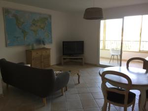 un salon avec une table et une télévision dans l'établissement Vacances idéales limite Sanary sur mer !! logement partagé Shared accommodation, à Ollioules