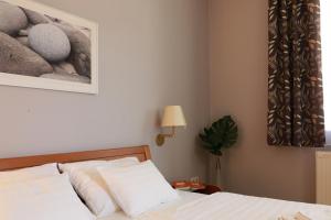 ヘーヴィーズにあるVita Apartmanokのベッドルーム1室(ベッド1台付)が備わります。壁に絵が飾られています。