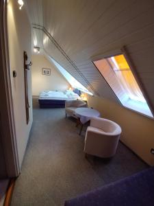 "ハルカーニャ"にあるEMMA Apartman Harkányのベッド2台と窓が備わる客室です。