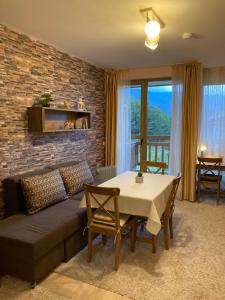 a living room with a couch and a table at Mirabell Apartment Bansko - Mountain View & Fireplace in Bansko