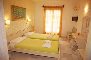 a hotel room with two beds and a sink at St.George Valsamitis in Katapola