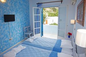 a blue bedroom with a bed and a sliding glass door at St.George Valsamitis in Katapola