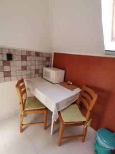 ハイドゥソボスローにあるMarika Apartmanのキッチンテーブル(椅子2脚、電子レンジ付)