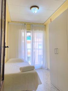 バレンシアにあるcheap roomsのベッドルーム1室(ベッド1台付)、窓、ドアが備わります。