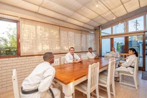 un grupo de personas sentadas alrededor de una mesa de madera en Villa Garda B&B, en Ciudad del Cabo 63 fotos más