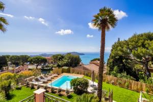 a villa with a swimming pool and a palm tree at Stunning seaview villa. Villefranche Sur Mer in Villefranche-sur-Mer