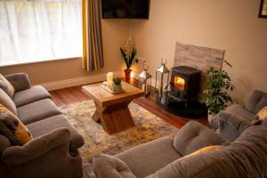 a living room with two couches and a wood stove at Drumlanaught Cottage Farnham in Cavan