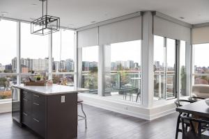- une cuisine avec de grandes fenêtres, une table et des chaises dans l'établissement LIV Extended Stay, à Ottawa