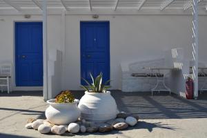 two large white vases on a patio with blue doors at Maistrali in Provatas