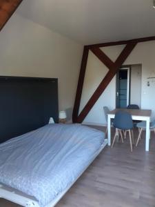 1 dormitorio con 1 cama grande y 1 mesa en Au coeur des remparts, residence du château*, en Gravelines