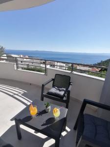 patio con mesa y silla en el balcón en Apartments Jakov, en Makarska