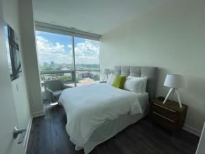 une chambre avec un grand lit et une grande fenêtre dans l'établissement LIV Extended Stay, à Ottawa