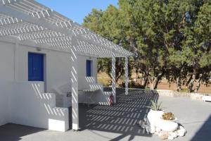 a white pergola in front of a building at Maistrali in Provatas