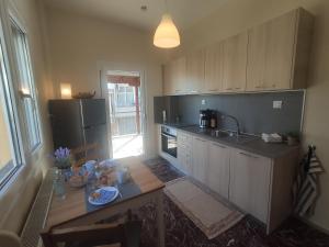 a kitchen with a table and a sink and a refrigerator at Neos Marmaras Holiday 2 in Neos Marmaras