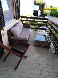 porche con sofá y silla en el balcón en Maria´s Haus en Novigrad Istria
