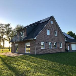 a large brick house with a gambrel roof at Ferienwohnungen Weide-Meer-Watt in Großheide