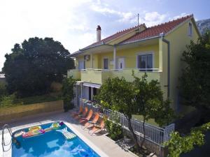 a villa with a swimming pool in front of a house at Beautiful villa - private heated pool, parking, BBQ near Split in Solin