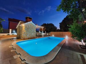 Beautiful villa - private heated pool, parking, BBQ near Split في سولين: وجود مسبح في الحديقة الخلفية ليلا