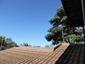 un techo de azulejos de una casa con un árbol en el fondo en Um paraiso em meio à cidade, en Campinas