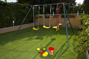 a playground with swings and toys on the grass at Beautiful villa - private heated pool, parking, BBQ near Split in Solin