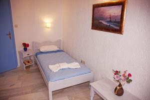 a small bedroom with a bed with towels on it at St.George Valsamitis in Katapola