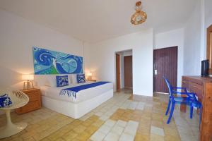 a bedroom with a bed and a table and a chair at Emperador Vallarta Beachfront Hotel and Suites in Puerto Vallarta