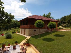 a building with a table and chairs in a yard at Kuca za uzivanje in Valjevo