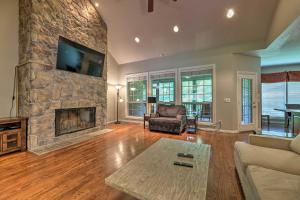 a living room with a stone fireplace and a tv at Bentonville Home with Pool Table, 2 Mi to Downtown! in Bentonville